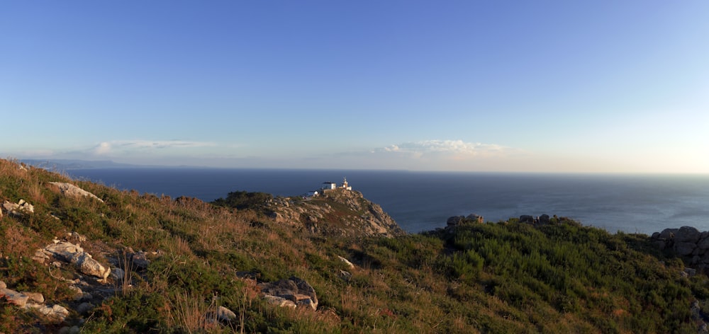 a rocky hillside overlooking a body of water