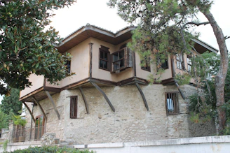 A traditional stone house in Fethiye, surrounded by lush greenery.
