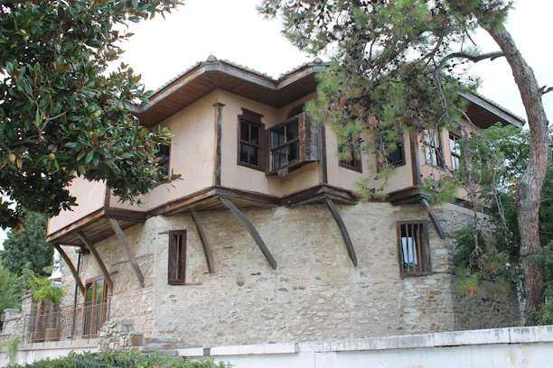 A traditional stone house in Fethiye, surrounded by lush greenery.