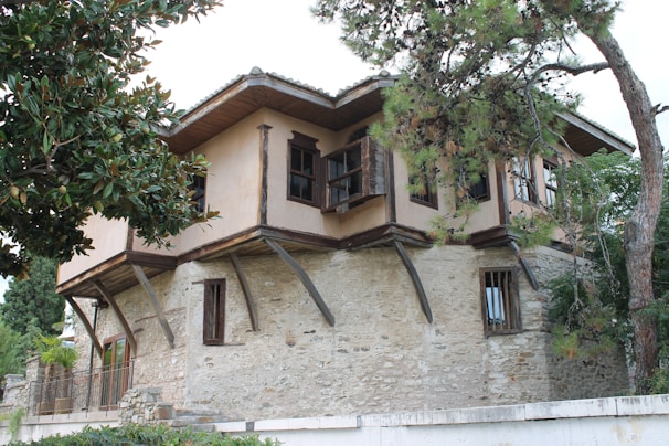 A traditional village house surrounded by trees.
