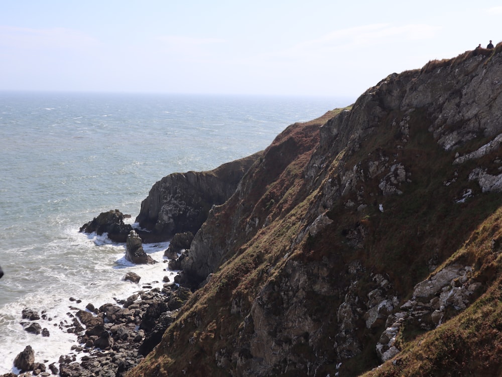 a rocky cliff next to the ocean