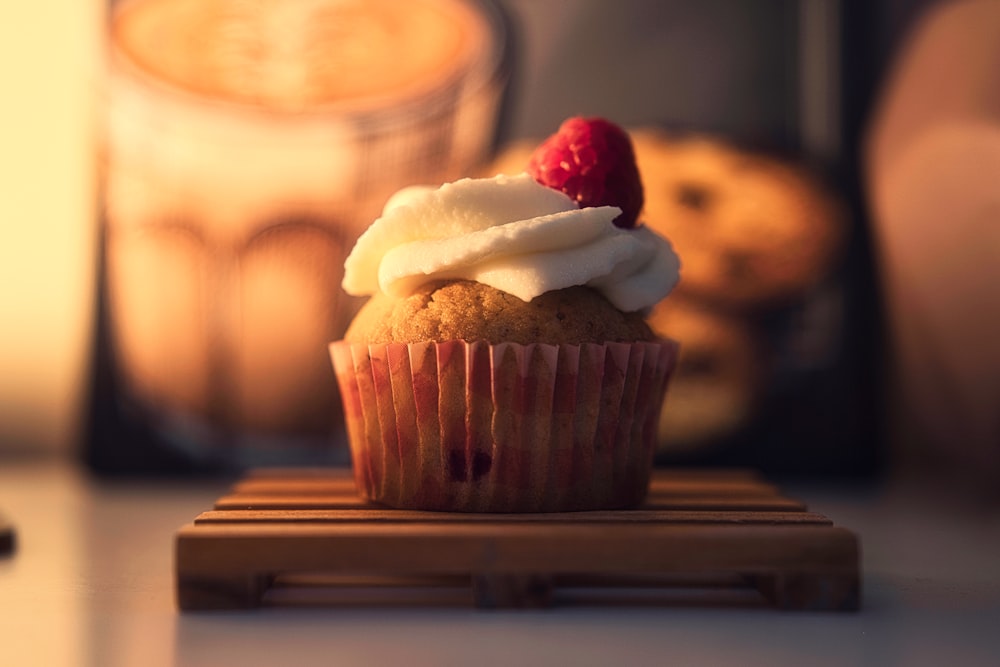 ein Cupcake mit weißem Zuckerguss und rot-weißem Topping
