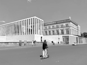A city commuter stylishly riding a streamlined electric scooter with tall buildings in the background.
