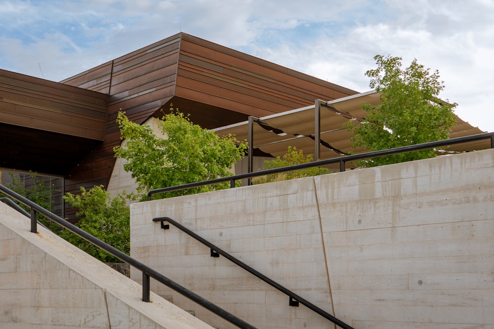 a building with a railing and trees