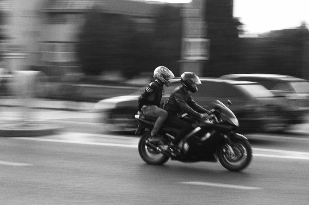 a couple of people ride a motorcycle