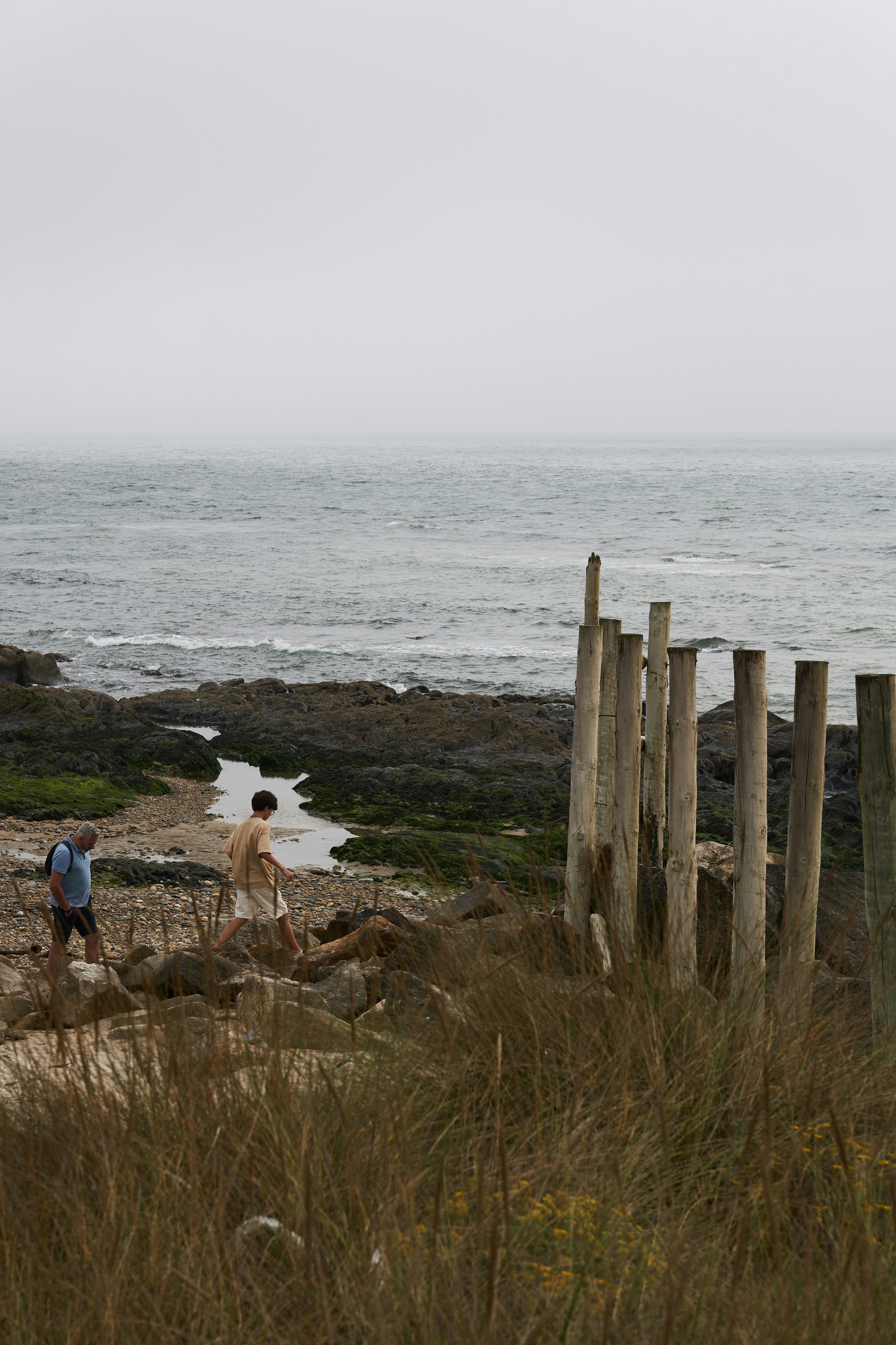two people walking on a beach