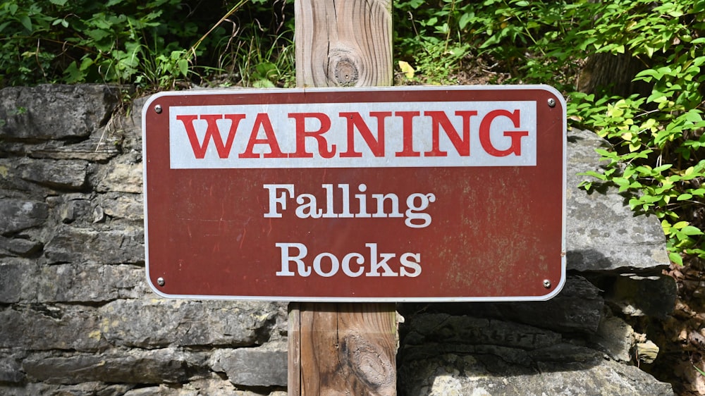 a red sign on a wooden post