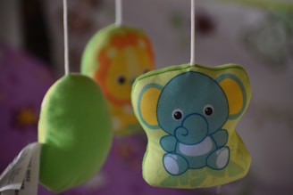 A soft pastel-colored baby mobile hanging above a crib, featuring gentle animal shapes.