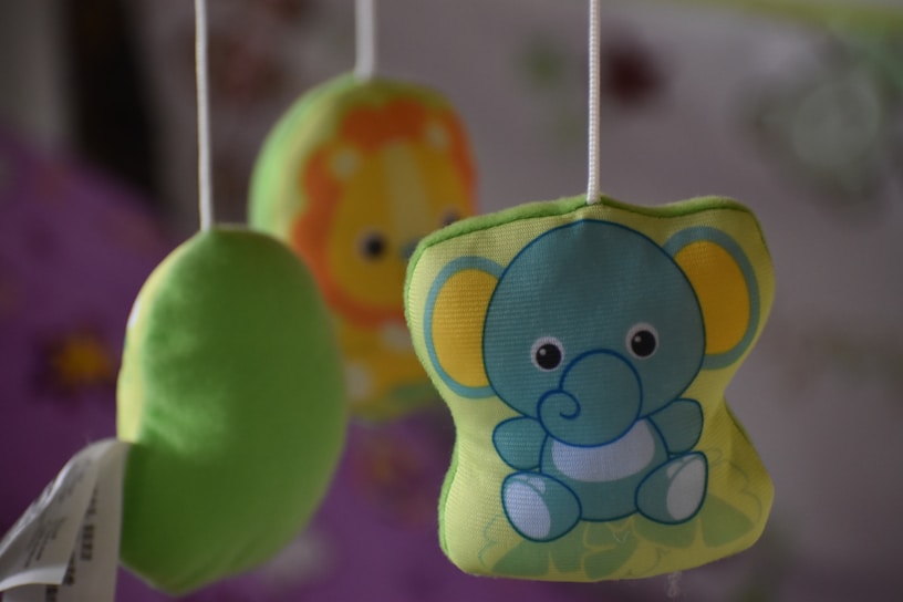 A soft pastel-colored baby mobile hanging above a crib, featuring gentle animal shapes.