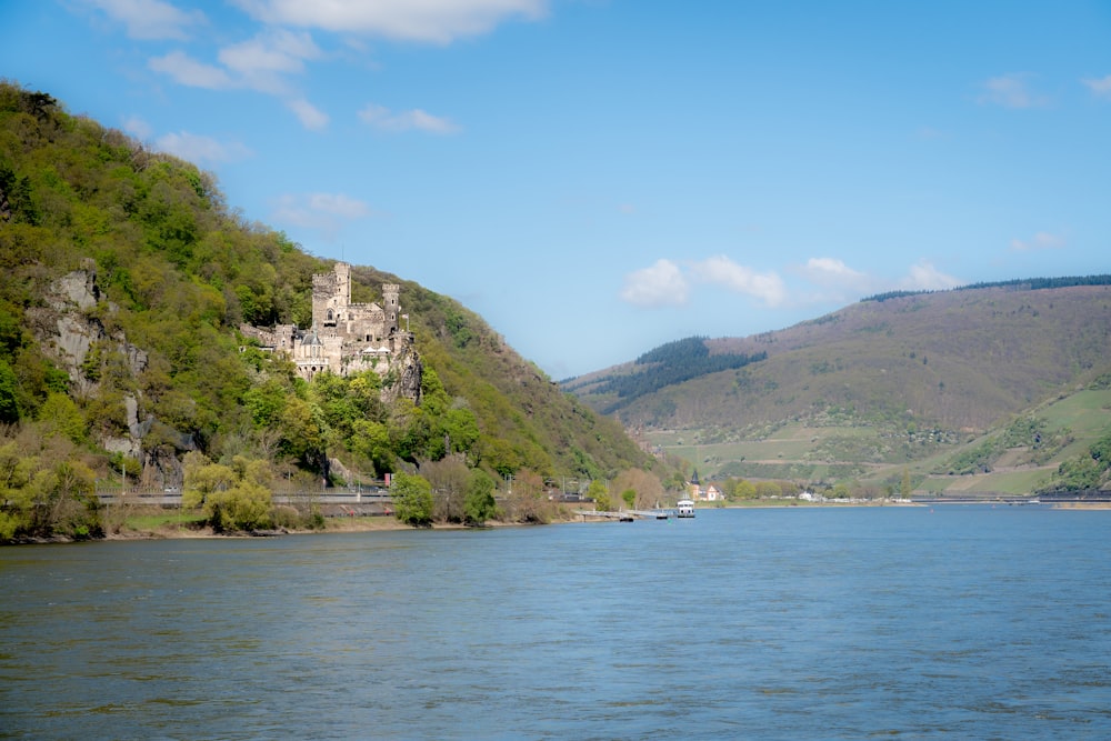 a castle on a hill by a lake