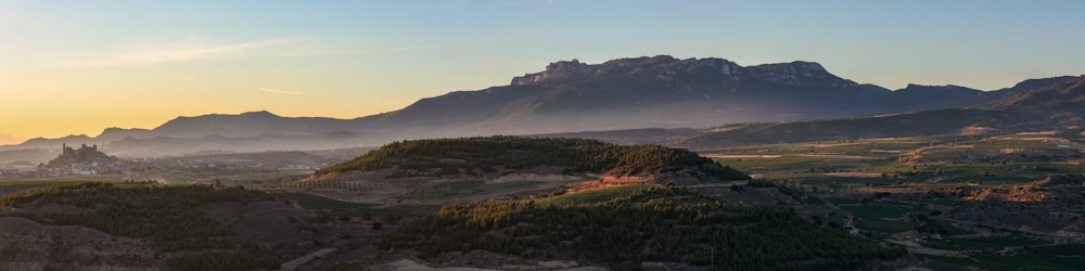 a landscape with hills and fog