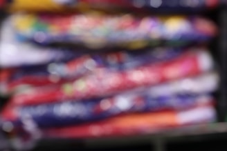 Close-up of colorful folded fabric stacks in a retail store.