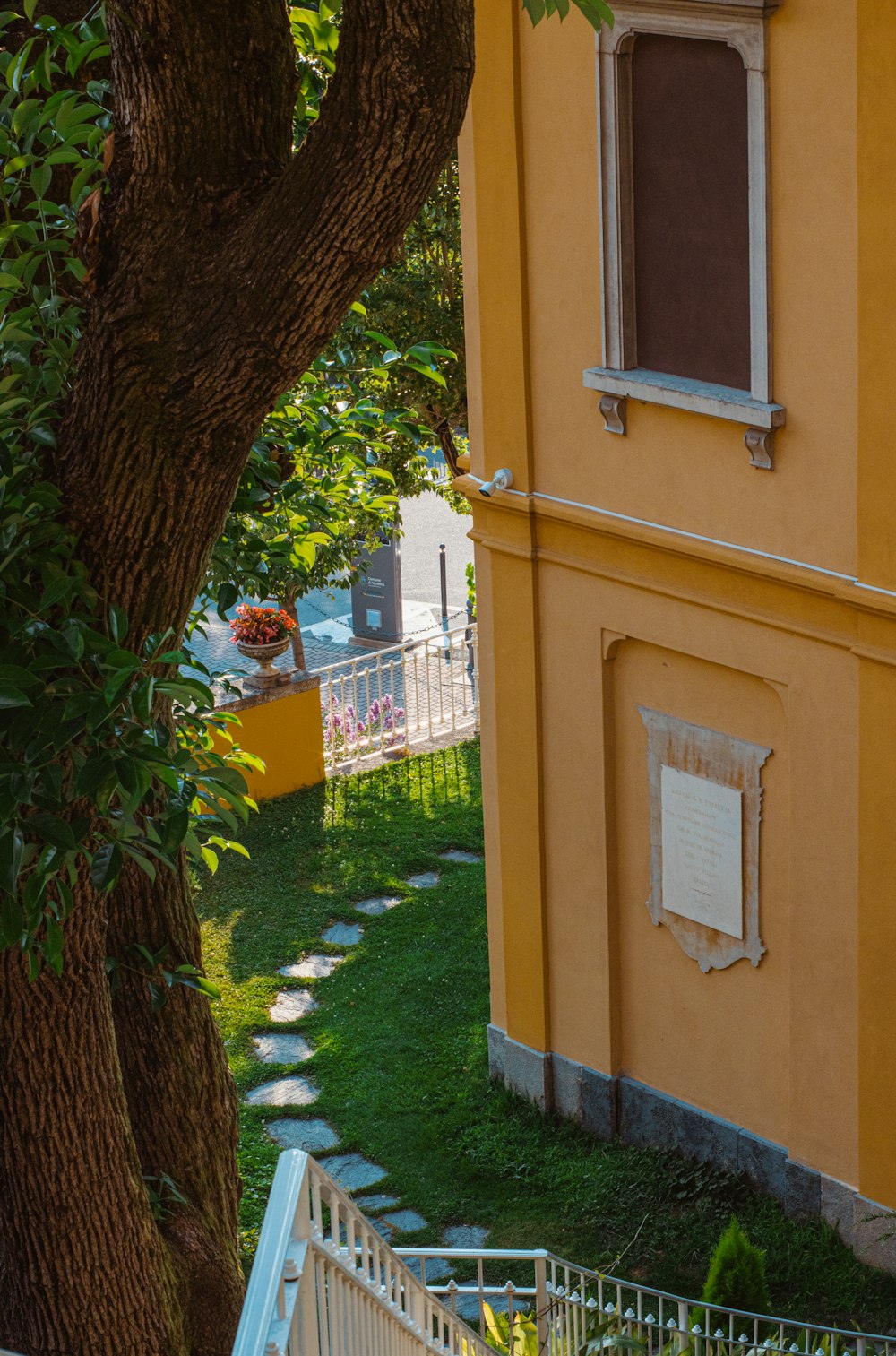 a yellow building with a green lawn