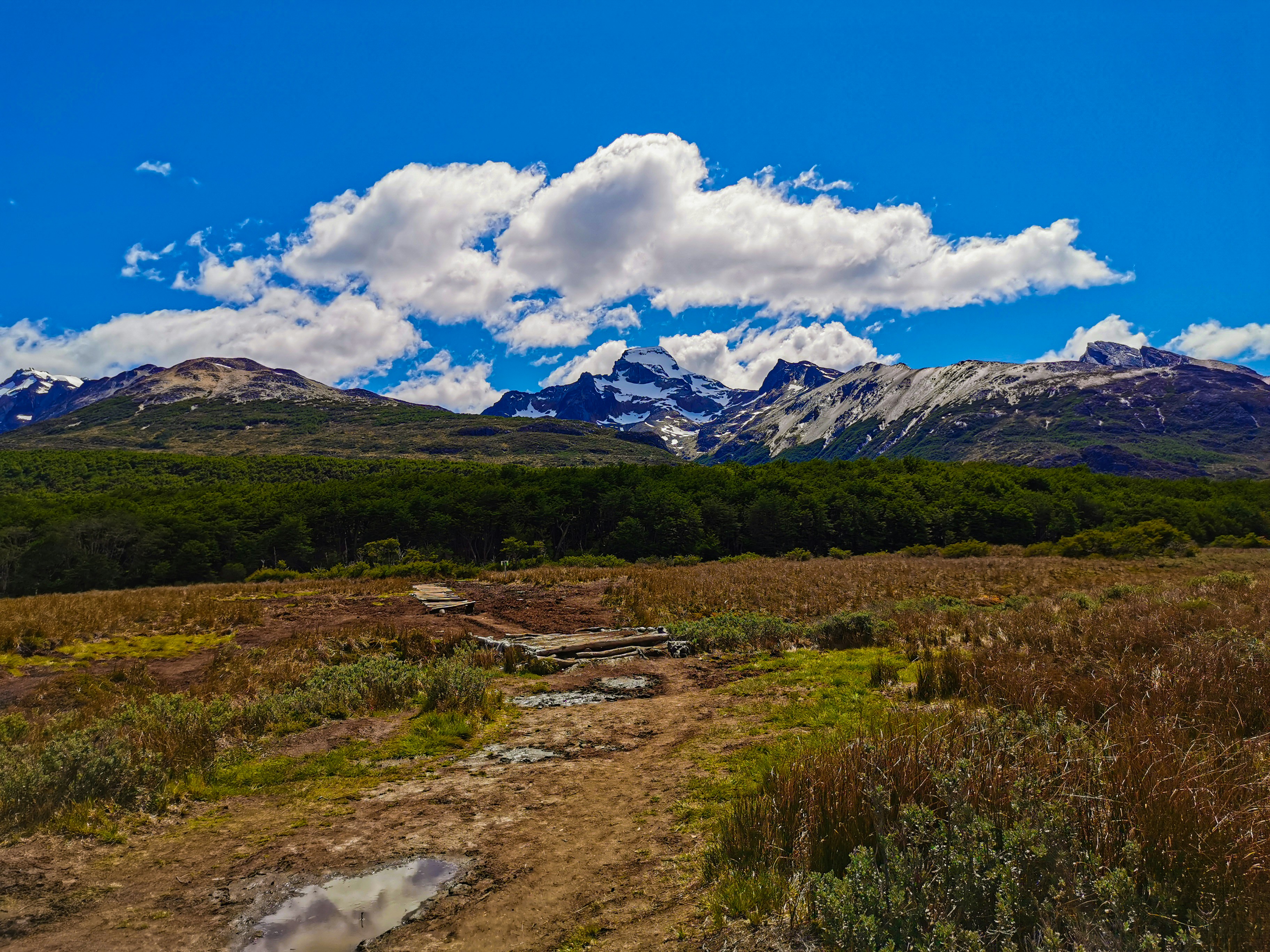 a dirt road leading to a mountain range