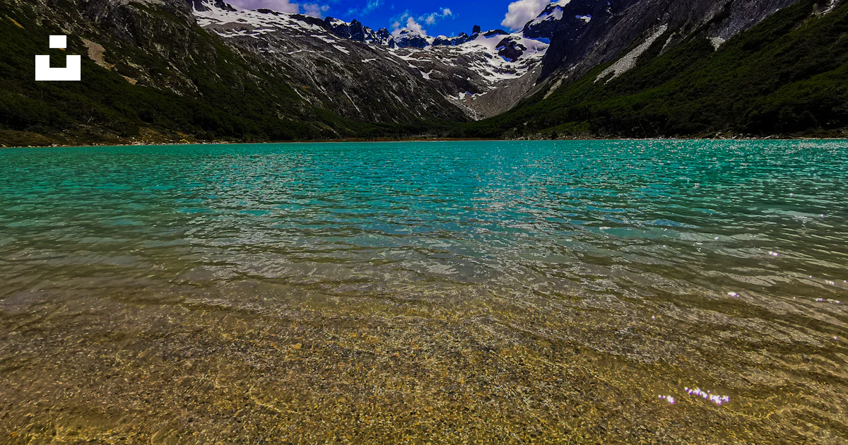 Un cuerpo de agua con montañas al fondo foto – Imagen de Laguna ...