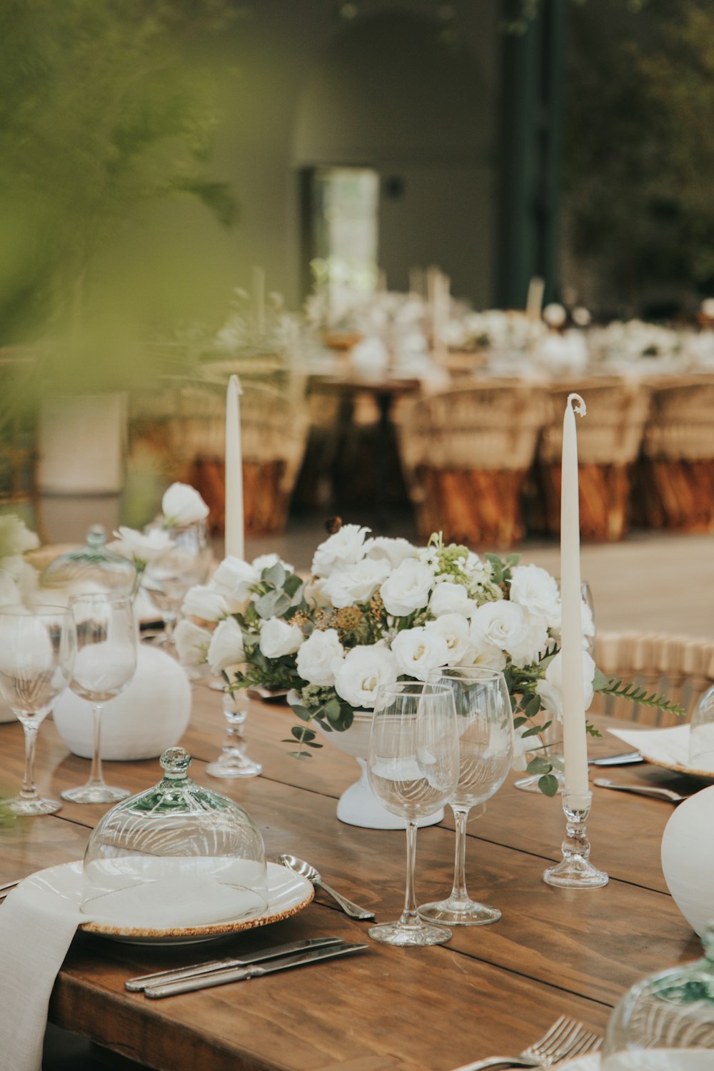 a table with white flowers and candles