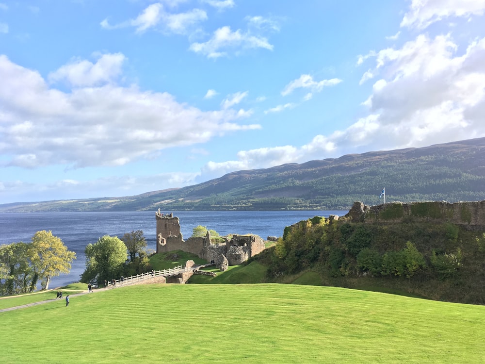 a castle on a hill by a lake