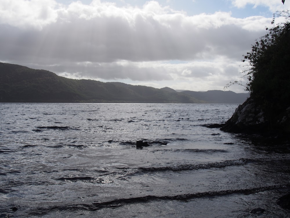 a body of water with hills in the background with Loch Ness in the background