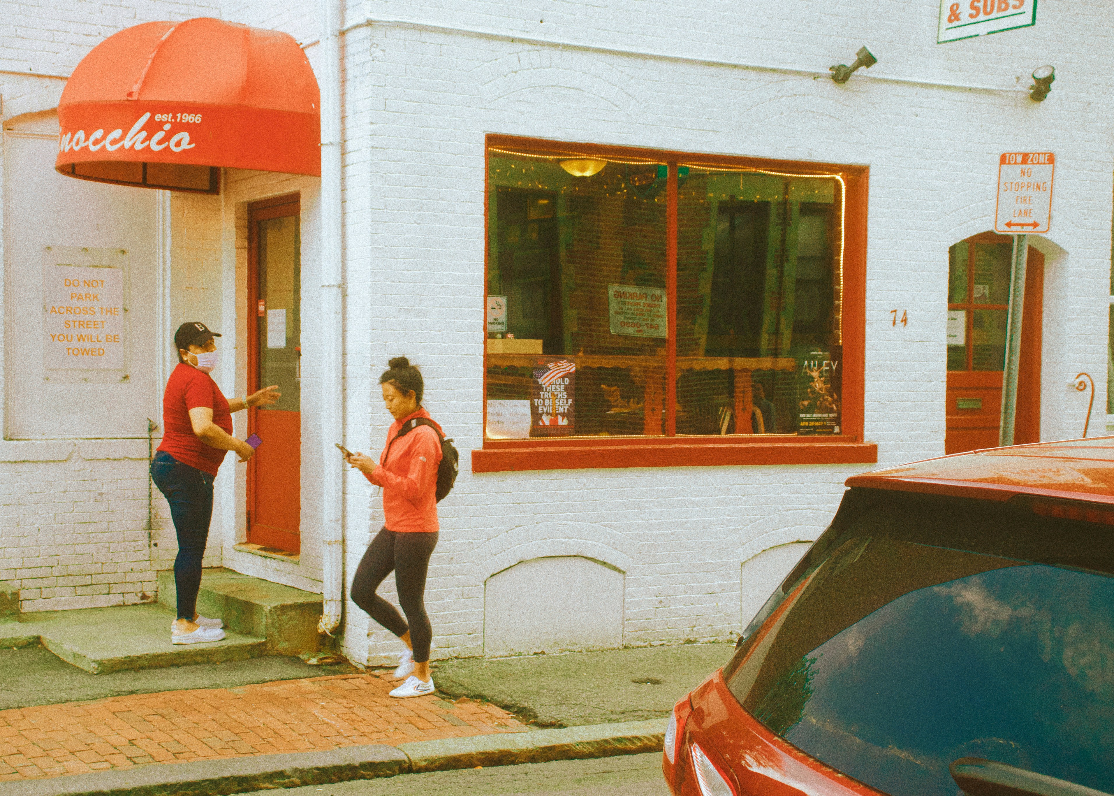 a couple of women standing outside a store