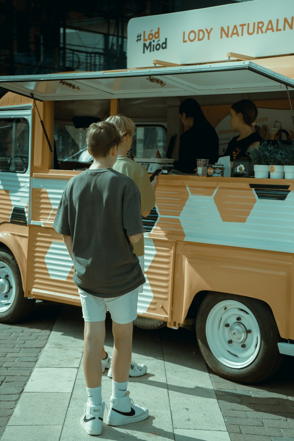 A boy standing in front of a food truck photo – Free Person Image on  Unsplash