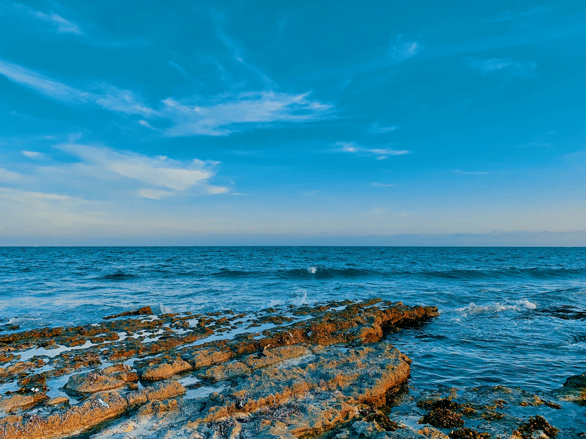 a rocky beach with a body of water in the background