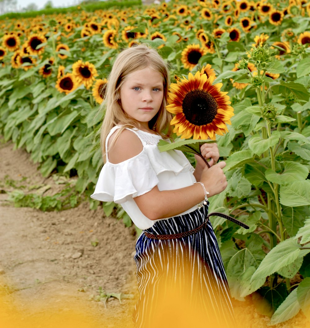 a girl holding a sunflower