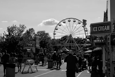 Wide shot of an outdoor fair with multiple stands and lively crowds.