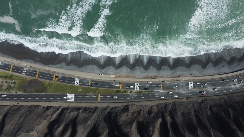 a race track with cars on it and a large body of water in the background