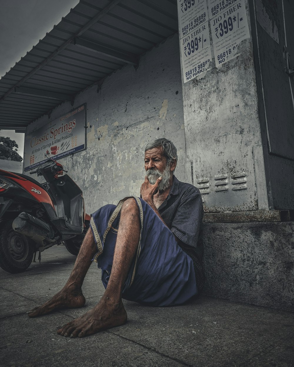 Un uomo seduto sul marciapiede