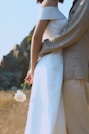 a person in a white dress holding a white flower