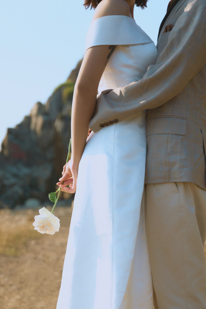 Pale ranunculus held against white cloth.