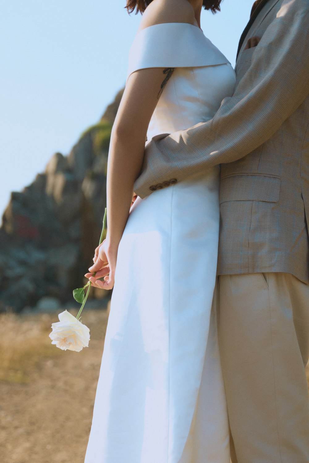 a person in a white dress holding a white flower