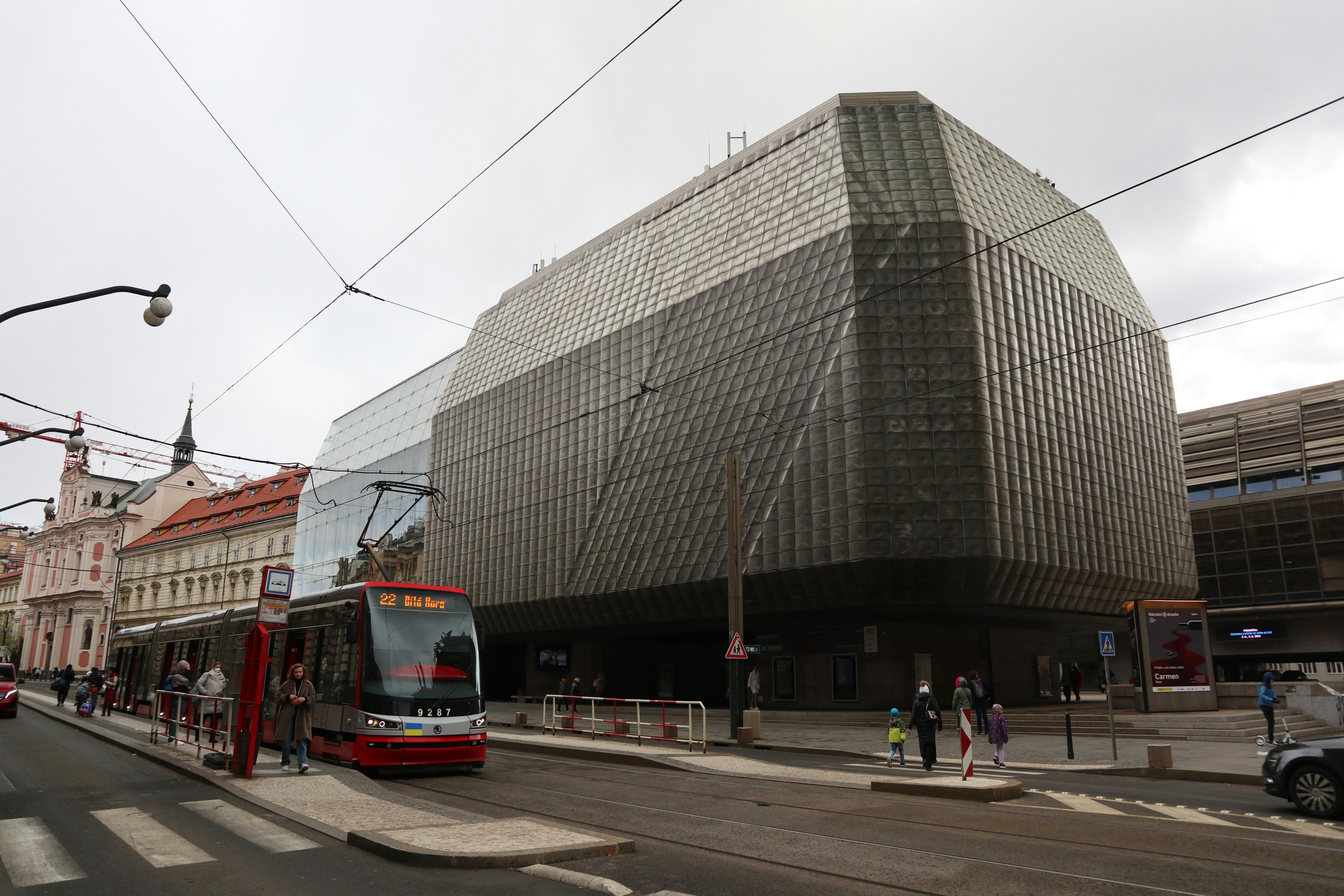 a bus driving by a large building
