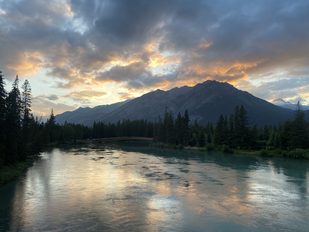 a lake with trees and mountains in the background