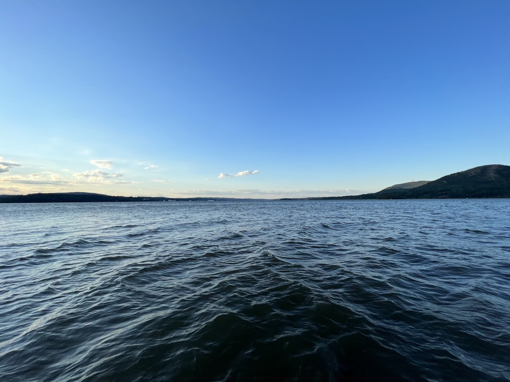 a body of water with hills in the background