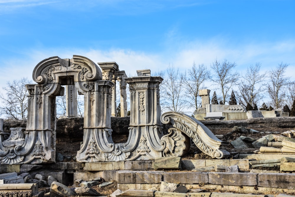 a stone structure with columns with Old Summer Palace in the background