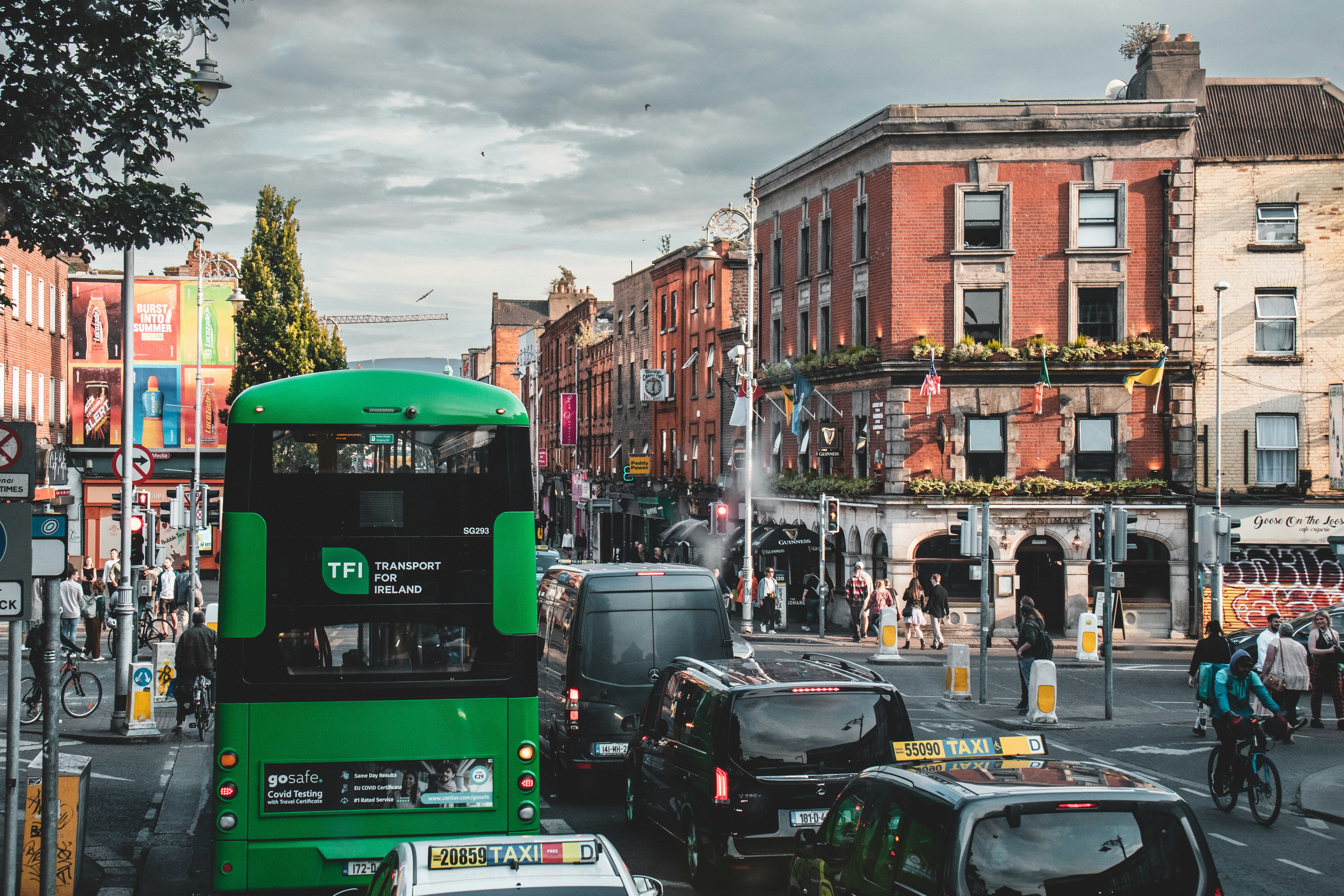a green double decker bus on the street