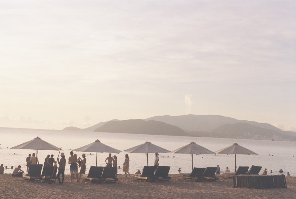 a group of people stand near each other on a beach