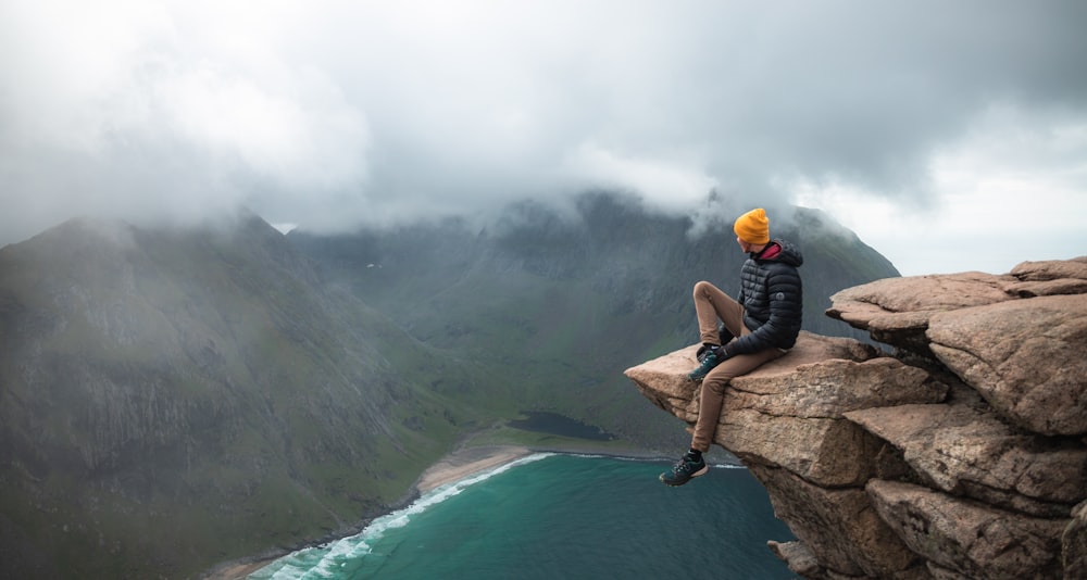 a person sitting on a rock overlooking a body of water