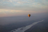Romantic hot air balloon ride over rolling hills at dawn.
