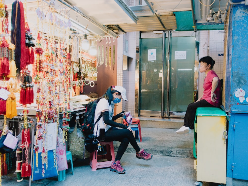 a couple of women sitting on a bench in a store