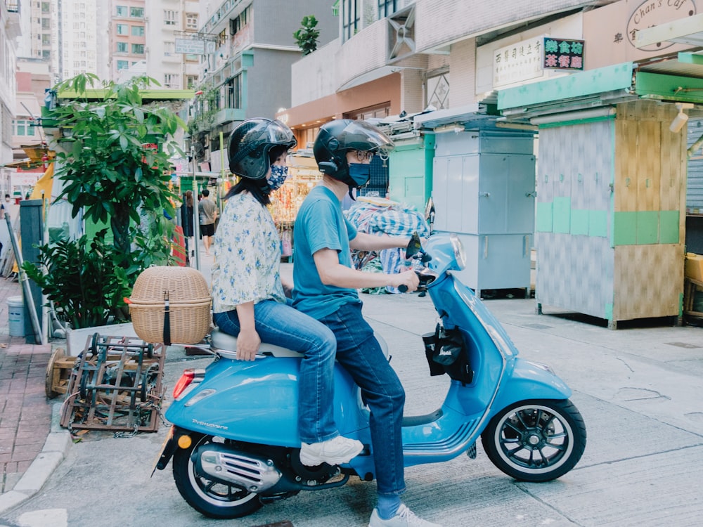 a man and a woman riding a scooter