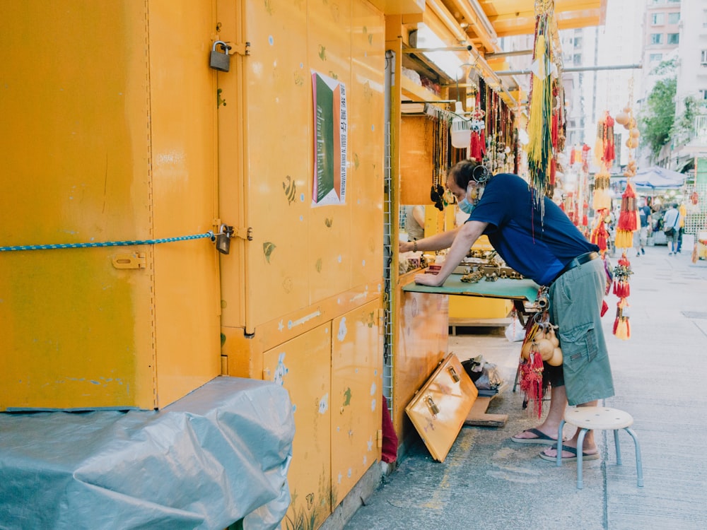 a person painting a yellow building