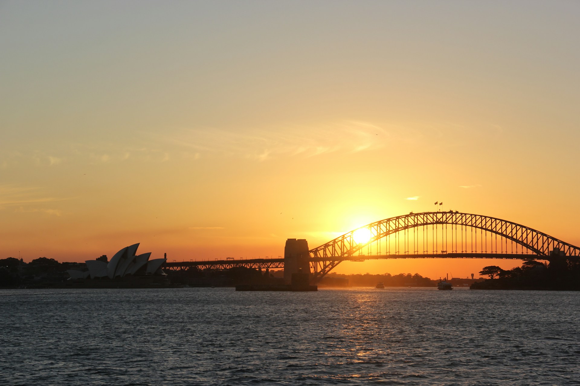 A stunning shot of the Sydney Harbour Bridge at sunset, with warm hues reflecting off the water.