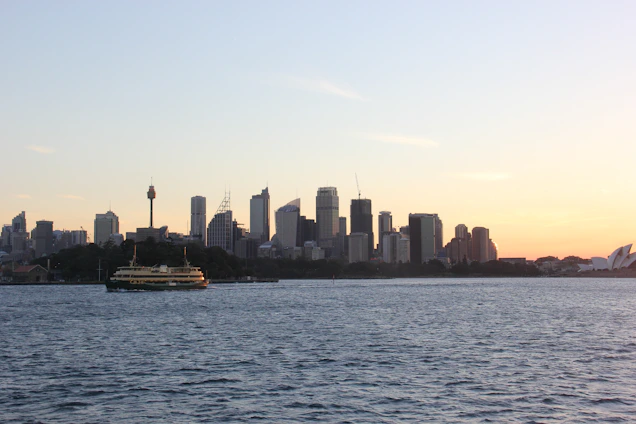 Courier driver handing over a package in front of Albany city skyline at sunset.