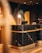 A modern and elegant hotel reception desk featuring a black marble finish with gold accents, complemented by a stylish lamp and computer on the countertop. The background displays a vibrant mural with geometric patterns and abstract art.