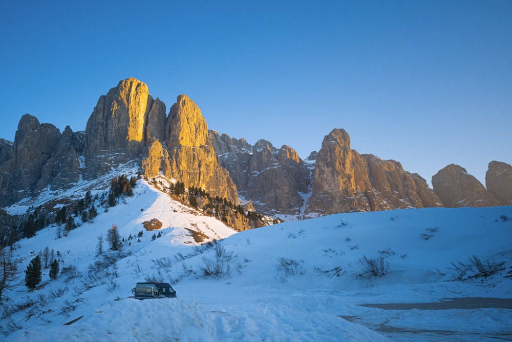 a snowy mountain with a car parked in front of it