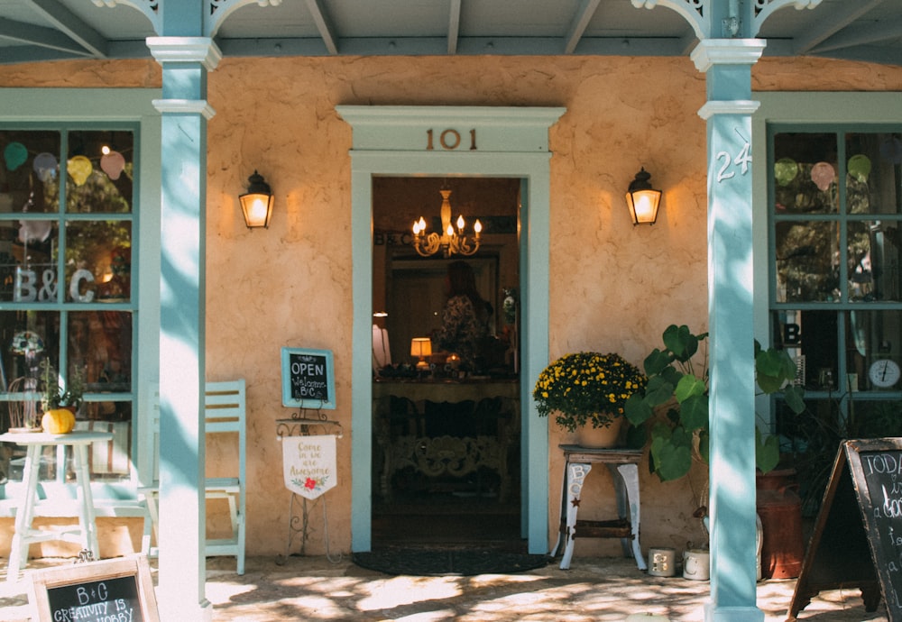 a building with a glass door and a table with chairs and plants