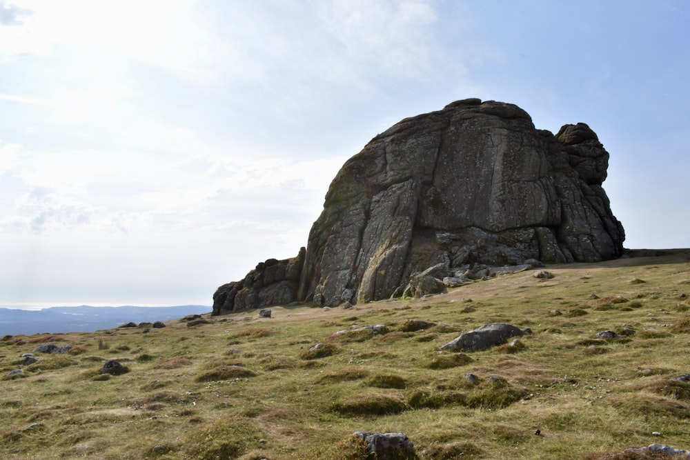 a large rock formation in a grassy field