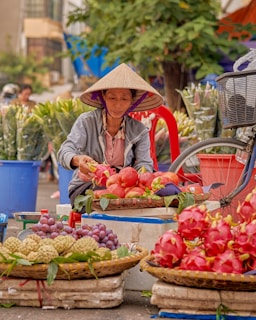a woman selling fruits at an outdoor market